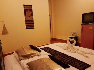 巴色的住宿－宣邁花園度假旅館，一张带两张毯子和一条毛巾的床
