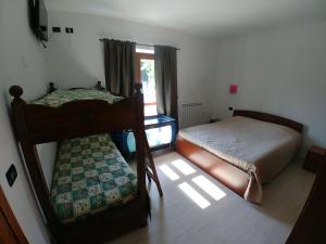 - une chambre avec 2 lits superposés et une fenêtre dans l'établissement Agriturismo Bastià, à Corio