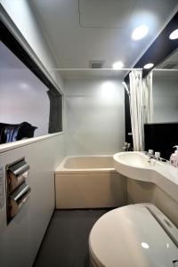 a bathroom with a toilet and a sink and a tub at Green Rich Hotel Iwakuni Ekimae (Artificial hot spring Futamata Yunohana) in Iwakuni