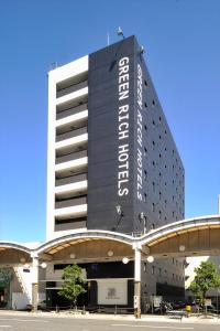 um edifício com um sinal na lateral em Green Rich Hotel Iwakuni Ekimae (Artificial hot spring Futamata Yunohana) em Iwakuni