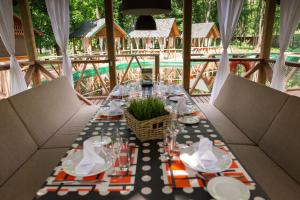 - une grande table avec des assiettes et des verres sur la terrasse dans l'établissement Dubrava Park-Hotel, à Samara