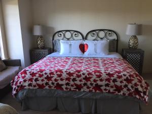 a bed with a red blanket and two hearts on it at Go House in Richmond