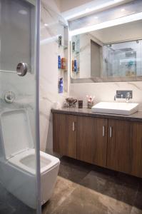 een badkamer met een wastafel, een toilet en een spiegel bij Lavasa Luxury Lakeview Studio in Lavasa