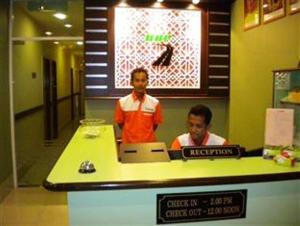 two men sitting at a counter in a store at BBP Hotel in Kota Bharu