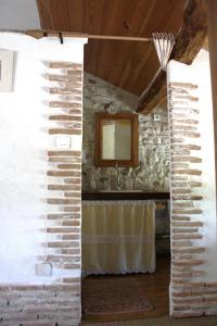 Habitación con pared de piedra y espejo. en Maison Basta, en Orthevielle