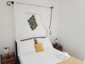 a bedroom with a white bed with a headboard at Sarakiniko Rooms in Adamantas