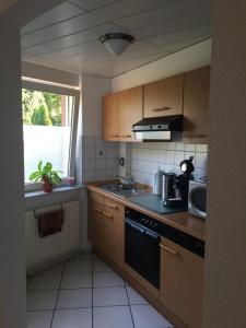 cocina con fregadero y fogones horno superior en Apartment am Park en Tönisvorst