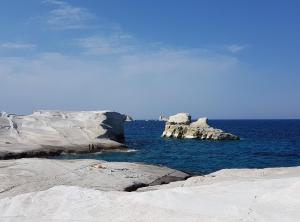 a view of the ocean with rocks in the water at Sarakiniko Rooms in Adamantas