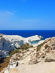 a group of rocks on a beach with the ocean at Sarakiniko Rooms in Adamantas