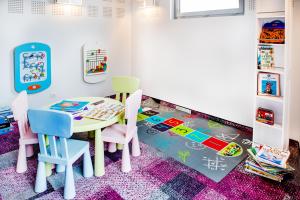 a childs play room with a table and chairs at Hôtel Sainte-Rose in Lourdes