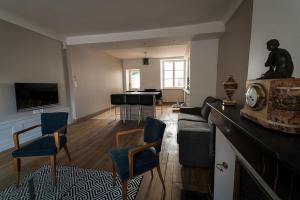 a living room with a couch and a piano at Les Gites Historiques in Mirecourt