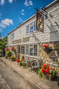 uma pousada com uma mesa e cadeiras fora dela em Victoria Inn em Cowbridge