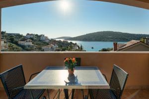 a table with a vase of flowers on a balcony at Holiday Home Mirna Vala in Sevid