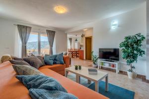 a living room with a couch and a tv at Holiday Home Mirna Vala in Sevid