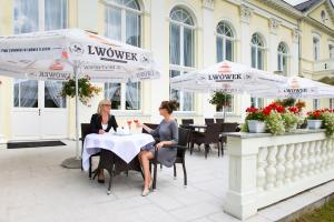 twee vrouwen aan een tafel onder parasols bij Edward in Jelenia Góra