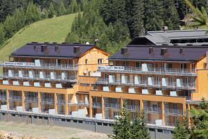a large building with a hill in the background at Haus CKPK Lux in Sonnenalpe Nassfeld