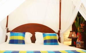 a bedroom with a bed with blue and yellow pillows at Villa Bird Gate in Galle