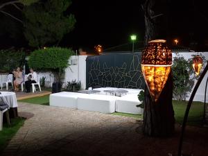 Un sofá blanco sentado junto a un árbol por la noche en Campomar Playa, en El Puerto de Santa María