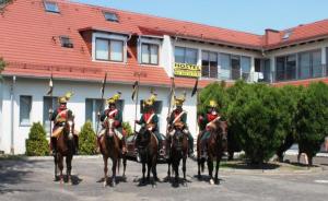 a group of people in uniform on horses in front of a building at Hostel Nuove Frontiere in Nysa
