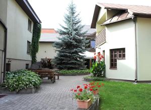 a courtyard with a christmas tree and a pine tree at Hotel Senas Namas in Alytus