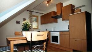 eine Küche mit einem Tisch und eine Küche mit einer Treppe in der Unterkunft Ferienhaus Feuerer in Obertraun