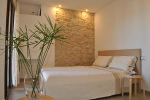 een slaapkamer met een bed en een stenen muur bij Casa Sant'Antoni in Baunei