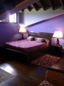 a bedroom with a bed with two lamps and a rug at Casona Los Gamonales in Carreno