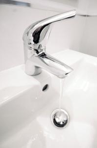 un rubinetto del lavandino con acqua che esce da esso di Humber Royal Hotel a Grimsby