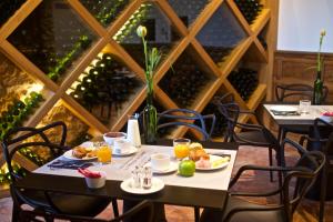 a dining room with two tables with food and drinks at Chateau Prieure Marquet in Saint-Martin-du-Bois