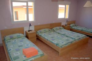 a room with two beds and two windows at Casa Rural Dunas in Santa María de la Alameda +121 photos