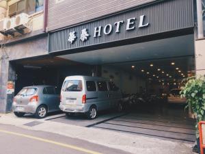 two cars parked in a parking lot in front of a hotel at Hua Tai Hotel in Hsinchu City