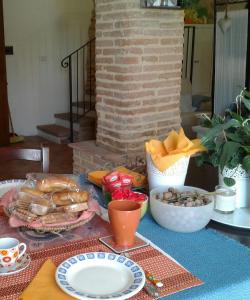 uma mesa coberta com pratos e tigelas de comida em Il giardino segreto em Contigliano