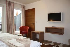 オーベルストドルフにあるホテル ガストホフ アドラーのベッドと壁にテレビが備わるホテルルームです。