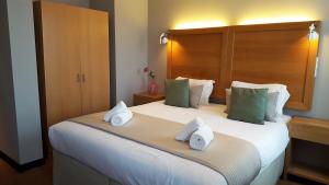 een slaapkamer met een groot bed en handdoeken bij The Bank Hotel in Amsterdam