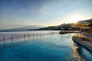 a large body of water with a pier at UNA HOTELS Capotaormina in Taormina