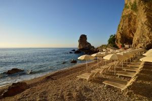 a group of chairs and umbrellas on a beach at UNA HOTELS Capotaormina in Taormina