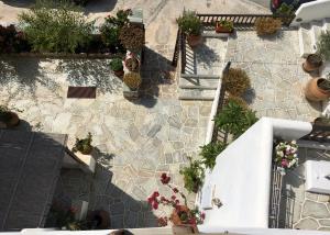 une vue sur un mur en pierre avec des plantes en pot dans l'établissement Antheia, à Folégandros