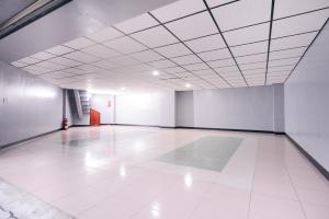 an empty room with a white tile floor and a ceiling at Guest Motel- Zhongli Branch in Pingzhen