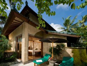 Bukit Naga Villa في غيانيار: بيت ضيافة فيه غرفة نوم ومظلة