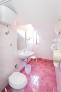 a bathroom with a white toilet and a sink at Hotel Concorde in Rome