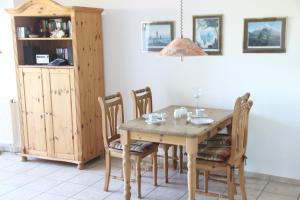 comedor con mesa de madera y sillas en Deichblick, en Sankt Peter-Ording