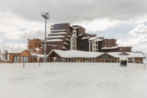 an empty hockey rink in front of a building at Residence L'Ours Blanc - maeva Home in L'Alpe-d'Huez