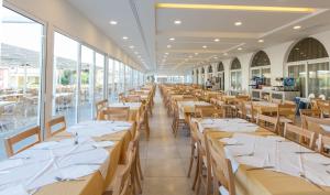 a restaurant with tables, chairs, and tables in it at Sun Palace Hotel in Faliraki