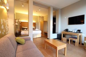 a living room with a couch and a bedroom at The Bank Hotel in Amsterdam