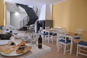 a dining room with a table and chairs and a staircase at La Gioia di Sicilia B&B in Avola