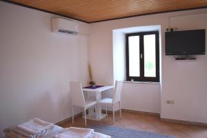 a room with a table and chairs and a tv at Apartment Bini in Molunat