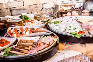 a table with many plates of food on it at Villa Magnat SPA, JACUZZI, SAUNA, TĘŻNIA SOLANKOWA in Białka Tatrzańska