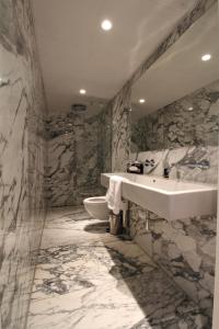 a marble bathroom with a sink and a toilet at The Bank Hotel in Amsterdam