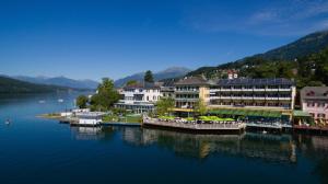 um grupo de edifícios sobre uma massa de água em SEEGLÜCK Hotel Forelle Superior em Millstatt