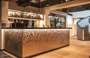 a bar in a room with a counter with drinks at Centennial Nexus Hotel Tallinn in Tallinn
